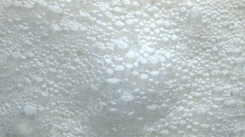 Preview: Foamy lactose drink surface top view. Milk liquid frothing texture closeup