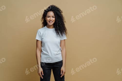 Preview: Attractive cheerful woman with Afro hairstyle smiles positively, rejoices buying new clothes