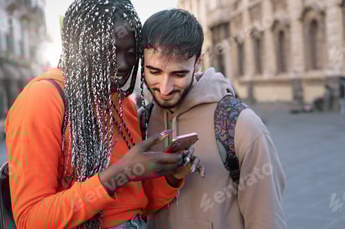 Preview: Multi-ethnic engaged couple of tourists watching content on the smartphone