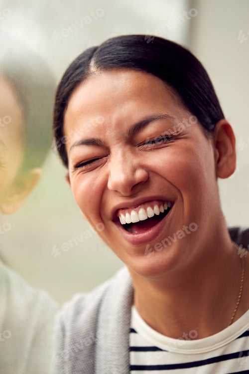 Preview: Head And Shoulders Portrait Of Woman Or Businesswoman Standing By Window In Office Or Home Laughing