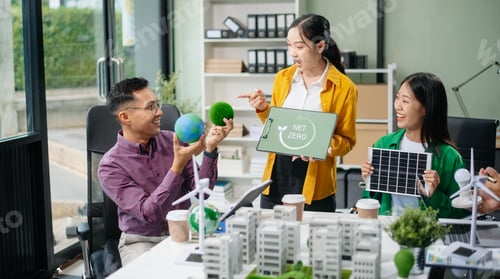 Preview: Group of diverse multiethnic businesspeople standing neare table looking at model of building from