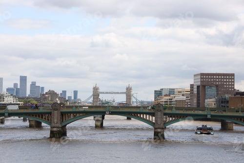 Preview: Beautiful cityscape of the Southwark Bridge over water in London, England with with a cloudy sky