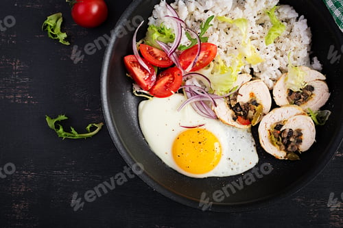 Preview: Fried egg, meat chicken roll, rice and tomatoes. Paleo breakfast.