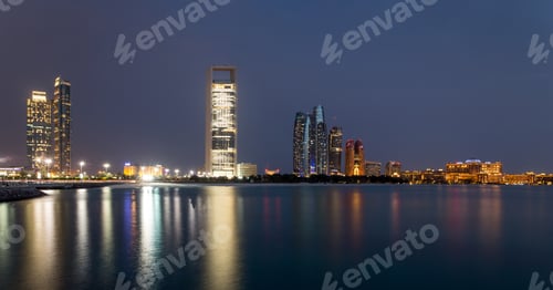 Vorschau: Skyline von Abu Dhabi zur blauen Stunde, Blick vom Meer mit Reflexionen von den Hochhäusern