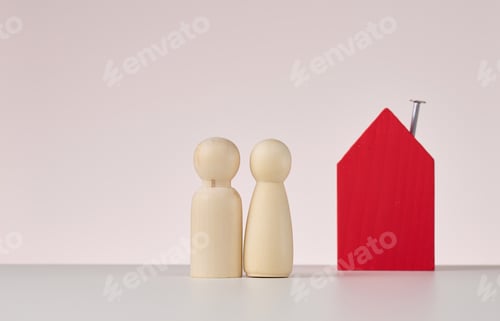 Preview: Wooden figures of men and a miniature house on a beige background