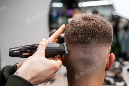 Preview: Barber cuts client short hair with trimmer in barbershop