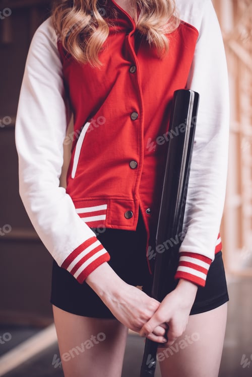 Preview: Stylish hipster woman in baseball jacket with black baseball bat