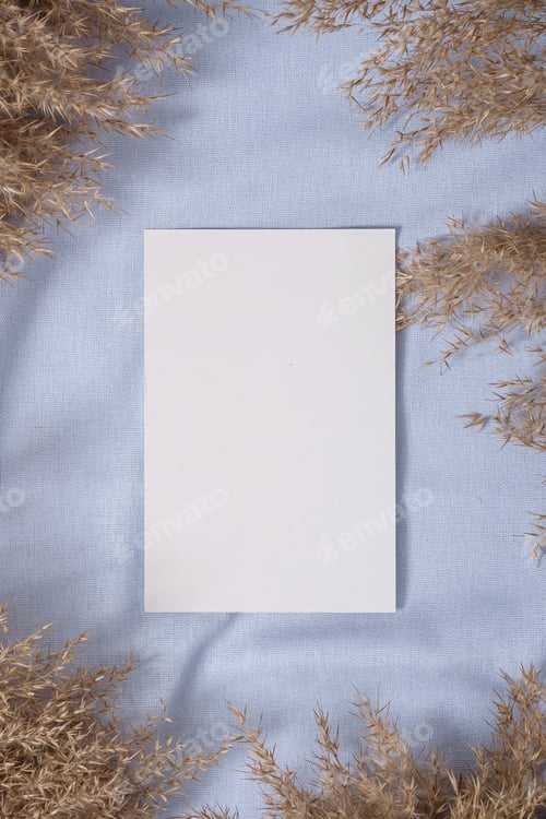 Preview: White blank paper card mockup with pampas dry grass on blue neutral colored textile
