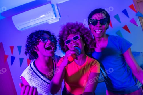 Preview: Happy multi-ethnic friends singing karaoke at night at the apartment