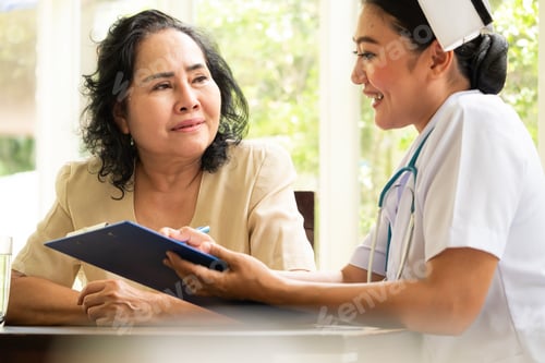 Preview: Beautiful nurse reporting healh results to adult female patient.
