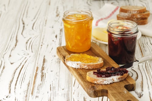 Preview: Slice of bread covered with fruit jam on wooden board