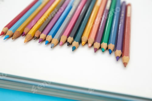 Preview: Colorful pencils on a blank notebook