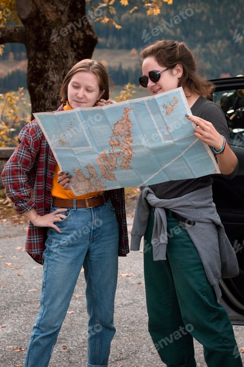 Preview: girl with a map is standing near the car