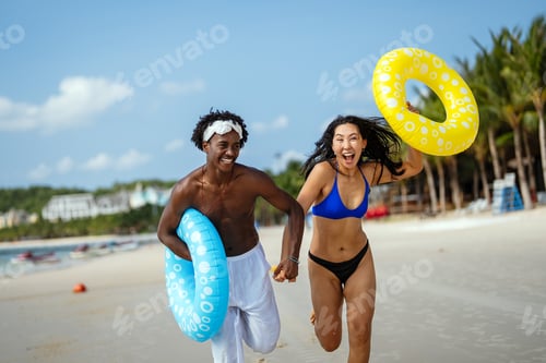 Preview: Interracial couple having fun at the beach, running through ocean waves on a tropical vacation