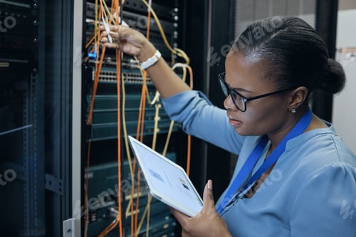 Preview: Cropped shot of an attractive female programmer working on a tablet in a server room