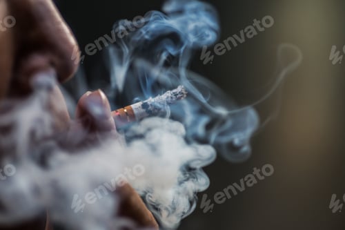 Preview: Closeup shot of a person puffing on a cigarette surrounded with smoke