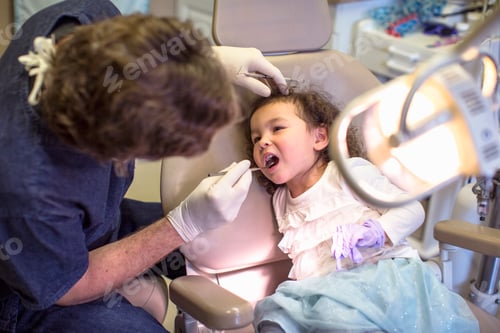 Preview: Dentist giving girl in dentist chair dental examination