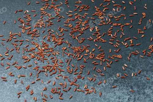 Preview: Scattered red rice grains on dark background, top view