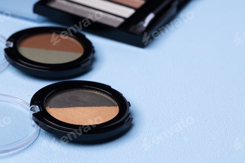 Preview: Set of eyeshadows on blue background close up
