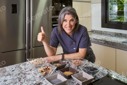 Preview: a female professional nutritionist with a bowl of legumes and carbohydrates with a nod of approval
