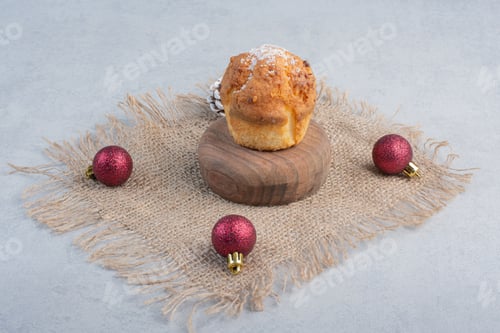 Preview: A cupcake and christmas decorations on a piece of cloth on marble background