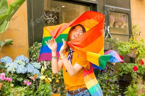 Preview: Young gay Chinese man with pride flag walking down the street