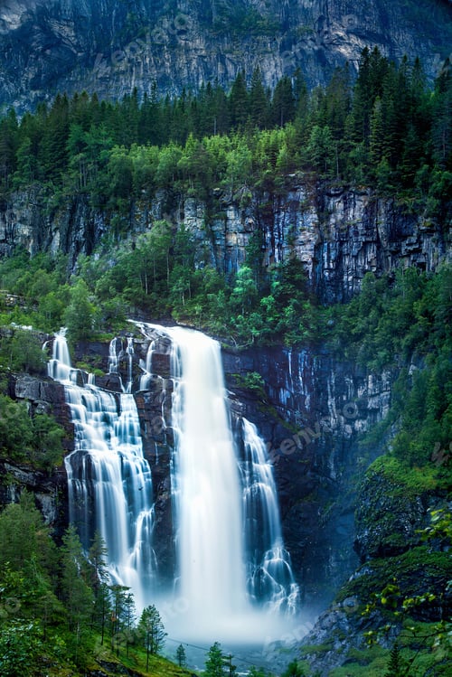 Preview: Skjervsfossen waterfall surrounded by pine forest and huge cliffs, near Voss, Norway