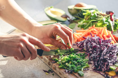 Preview: Woman cutting and chopping onion by knife on wooden board.