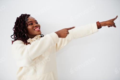Preview: African woman in hoodie stand against white wall and show fingers right.