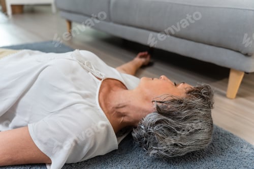 Preview: Caucasian senior woman fall on the ground alone in living room at home.