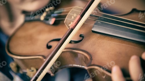 Preview: Close up on a bow and a violin played by a Young musician