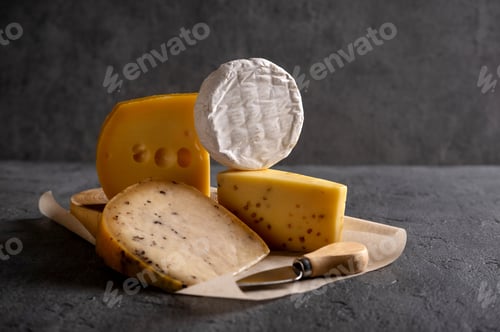 Preview: Various types of cheese on grey board. Dark moody. Free space for your text. Closeup.