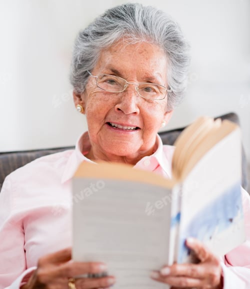 Preview: Retired Woman Reading A Book At Home And Smiling