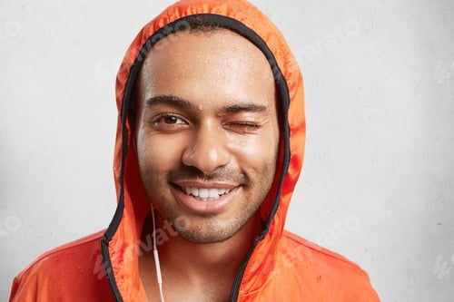 Preview: Sweaty male couch or trainer, wears hood, listens music with earphones and electronic device, blink