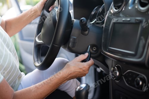 Preview: Close-up on senior woman in t-shirt entering her car. With one hand woman is holding the key
