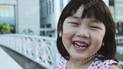 Preview: Happy Little Girl Laughing on a City Bridge