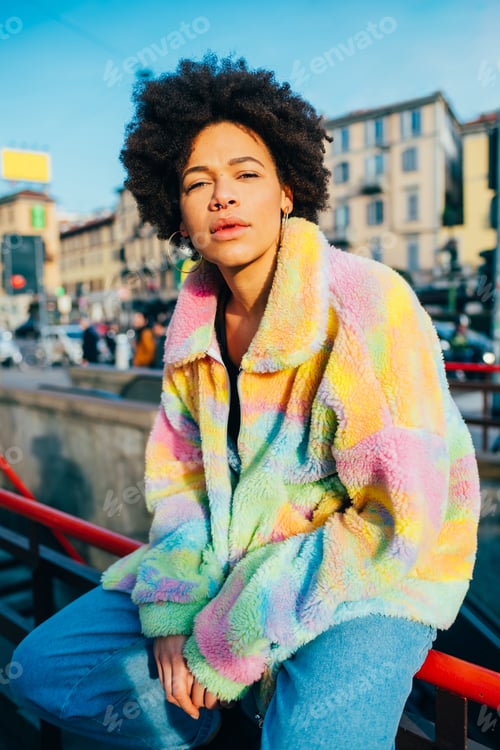 Preview: Young black curly hair fashionable cool woman posing outdoor looking camera