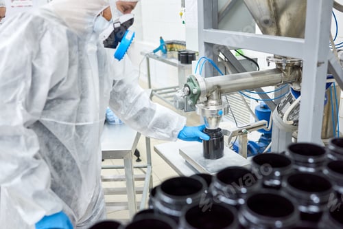 Preview: Factory worker filling plastic container with product