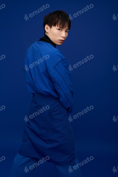 Preview: Striking pose of young handsome asian man against bold blue backdrop creates stunning visual impact