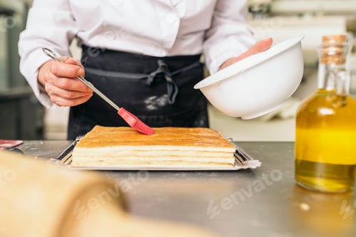 Preview: Female pastry chef decorating dessert in the kitchen.