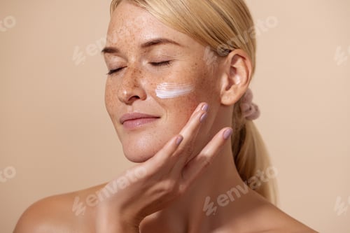 Preview: Close up of beautiful young female with cream on a face