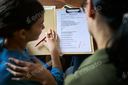 Preview: Teenage Girl Reviewing Graded School Assignment with Mother