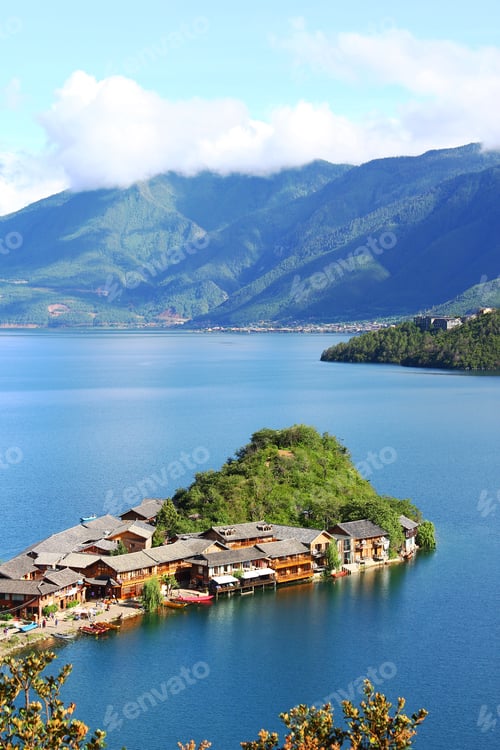 Preview: Vertical shot of a small island with residential houses surrounded by Lugu Lake in China
