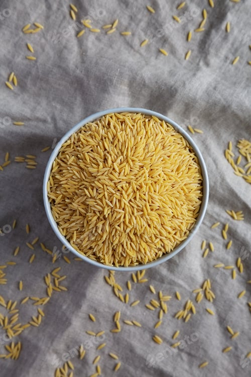 Preview: Raw Organic Risoni Pasta in a Bowl, top view. Flat lay, overhead, from above.