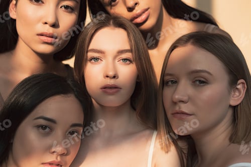 Preview: five beautiful multicultural girls looking at camera in sunlight