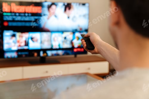 Preview: Happy man watching tv and eating popcorn