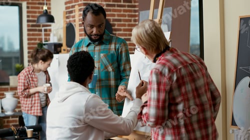 Preview: Team of students discussing sketch drawing with old artist