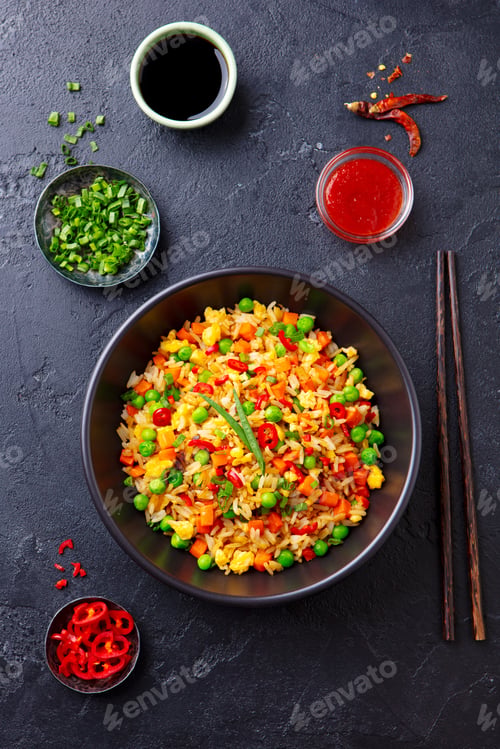 Preview: Asian Fried Rice with Egg and Vegetables. Dark Stone Background. Top view.