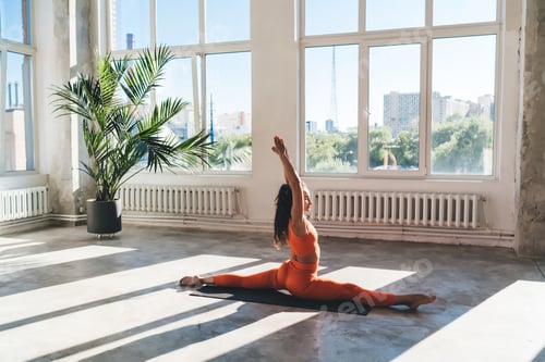 Preview: Fit sportswoman doing yoga in pose in spacious studio