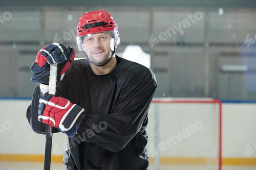 Preview: Mature male hockey player in sports uniform, helmet and gloves holding stick